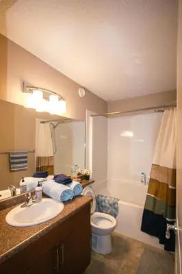 a bathroom with a sink and a toilet and a tub at Entire Home AC 4Beds Sleeps 8 Double Garage Near WEM Free Wifi & Netflix in Edmonton