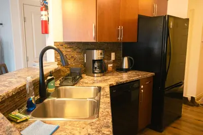 a kitchen with a sink and a black refrigerator at Entire Home AC 4Beds Sleeps 8 Double Garage Near WEM Free Wifi & Netflix in Edmonton