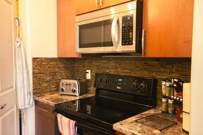 a kitchen with a black stove and a microwave at Entire Home AC 4Beds Sleeps 8 Double Garage Near WEM Free Wifi & Netflix in Edmonton