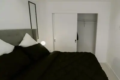 a bedroom with a bed with black sheets and white pillows at Vibrant & Modern Loft-style Walkout Near LRT in Calgary