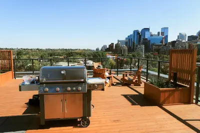 a grill on a deck with a view of the city at Vibrant & Modern Loft-style Walkout Near LRT in Calgary