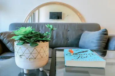 a book sitting on a table next to a potted plant at Vibrant & Modern Loft-style Walkout Near LRT in Calgary