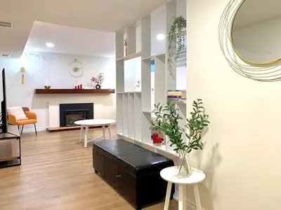 a living room with a fireplace and a mirror at 3Beds 2BA Cherry Blossom Suite - Free Parking - Central Oakridge Neighbourhood in Vancouver