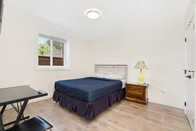 a bedroom with a bed and a desk and a window at William Place in Surrey
