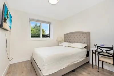 a white bedroom with a bed and a window at William Place in Surrey