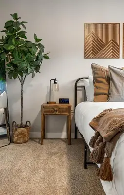 a bedroom with a bed and a table with a plant at Serene Peaks, Private Hot Tub, Peaceful in Radium Hot Springs