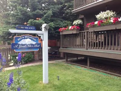 a sign in the grass in front of a house at A Good Nite's Rest Bed and Breakfast in Banff