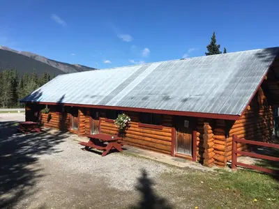 a log cabin with a picnic table in front of it at Double G Service in Muncho Lake