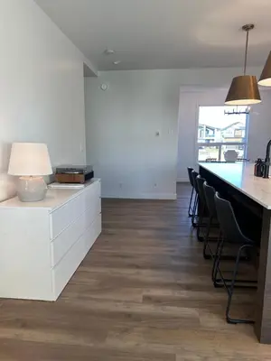 a kitchen with white cabinets and a table and chairs at The Evergreen House in Red Deer