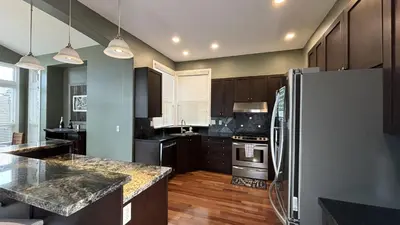 a kitchen with a refrigerator and a stove top oven at Metropolitan Dream Stay with Saltwater Pool and Hot Tub in Surrey