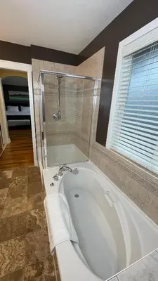 a white bath tub in a bathroom with a window at Metropolitan Dream Stay with Saltwater Pool and Hot Tub in Surrey