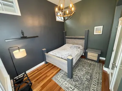 a small bedroom with a bed and a rug at Metropolitan Dream Stay with Saltwater Pool and Hot Tub in Surrey