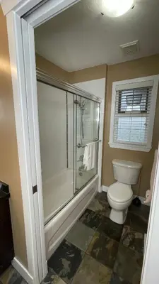 a bathroom with a toilet and a glass shower at Metropolitan Dream Stay with Saltwater Pool and Hot Tub in Surrey
