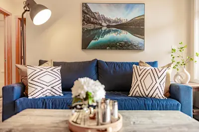 a blue couch in a living room with a table at Canmore Mountain Views -3Beds-Ski Stay Deals in Canmore