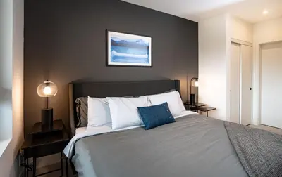 a bedroom with a large bed with a blue pillow at Revy's Peak Condo - Hot Tub with View in Revelstoke