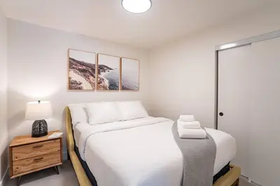 a bedroom with two beds and a night stand with a lamp at Rocky Ridge Getaway - Modern Getaway in Revelstoke in Revelstoke