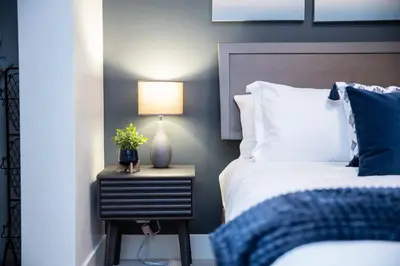 a bedroom with a bed and a lamp on a night stand at Selkirk Staytion - Stylish Condo with Hot Tub in Revelstoke