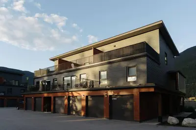 a black building with a balcony on top of it at The Nest - Condo with Hot Tub & BBQ in Revelstoke