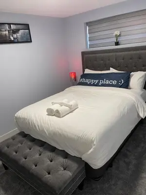 a bed with two towels on top of it at The Cozy Cove - Modern Private Basement Suite with Comfort & Charm, Free Parking, WiFi, Netflix Close to airport & 18 minutes to West Edmonton Mall in Edmonton