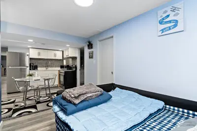 a bedroom with a bed and a kitchen with a table at The Cozy Cove - Modern Private Basement Suite with Comfort & Charm, Free Parking, WiFi, Netflix Close to airport & 18 minutes to West Edmonton Mall in Edmonton