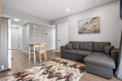 a living room with a couch and a table at Sunny Walk-out Unit, Free HiSpeed Wi-Fi and Parking, Near Grocery in Calgary