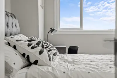 a bedroom with a bed with a window at Sunny Walk-out Unit, Free HiSpeed Wi-Fi and Parking, Near Grocery in Calgary