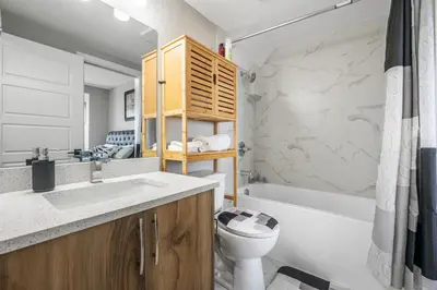 a bathroom with a sink and a toilet and a tub at Sunny Walk-out Unit, Free HiSpeed Wi-Fi and Parking, Near Grocery in Calgary