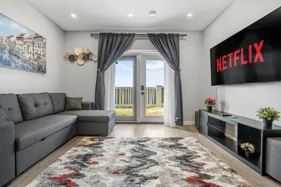 a living room with a couch and a television at Sunny Walk-out Unit, Free HiSpeed Wi-Fi and Parking, Near Grocery in Calgary