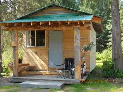 a small wooden cabin with a porch and a chair at Bone Creek Wilderness Retreat in Blue River
