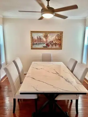 a dining room table with chairs and a ceiling fan at Crescent Heights Majesty in Calgary