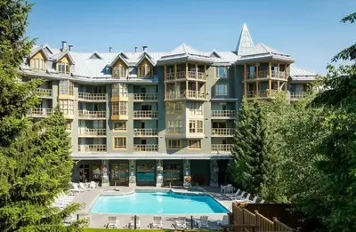 a large apartment building with a large swimming pool at Renovated 2Bed-2Bath in Village with Pool, Hot Tub, and Sauna in Whistler