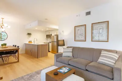 a living room with a couch and a kitchen at Renovated 2Bed-2Bath in Village with Pool, Hot Tub, and Sauna in Whistler