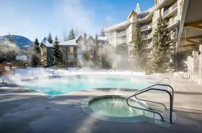 a swimming pool in front of a apartment building at Renovated 2Bed-2Bath in Village with Pool, Hot Tub, and Sauna in Whistler
