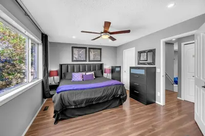 a bedroom with a bed and a ceiling fan at 12 Spacious Home W Ac, Crib, Garage, By Airport in Calgary
