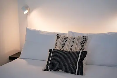 a bed with white pillows and a black and white pillow at Wildflower Retreat by Revelstoke Vacations in Revelstoke