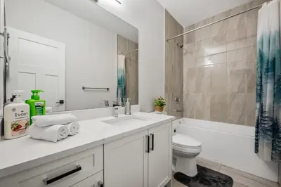 a white bathroom with a sink and a toilet at Luxury Retreat For Large Groups in Calgary