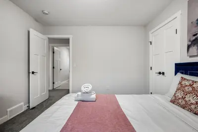 a bedroom with a large white bed with a red rug at Luxury Retreat For Large Groups in Calgary