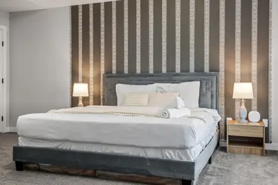a bedroom with a large white bed with two lamps at Luxury Retreat For Large Groups in Calgary