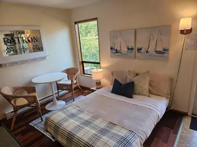 a bedroom with a bed and a table and chairs at Pebbly Beach Suite in Snug Cove in Bowen Island