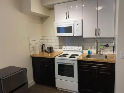 a kitchen with a white stove top oven next to a sink at Calming 1bedroom Units With Balcony And City View in Edmonton