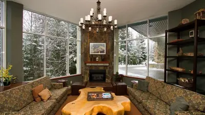 a living room with couches and a table and a fireplace at Woodrun Lodge 216 | Renovated Ski-In Ski-Out Condo w/ Free Parking, Pool, Hot Tub, & Gym in Whistler