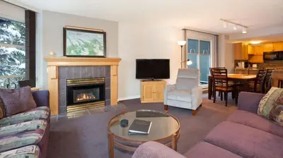 a living room with a couch and a fireplace at Woodrun Lodge 217 | Ski-In Ski-Out Condo - Walk to Upper Village w/ Hot Tub, Pool + Free Parking in Whistler