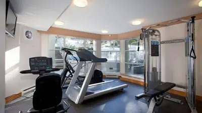 a room with a gym with a treadmill and a window at Woodrun Lodge 214 | Ski-in-Ski-Out Condo, Heated Pool, Hot Tub, Gym in Whistler