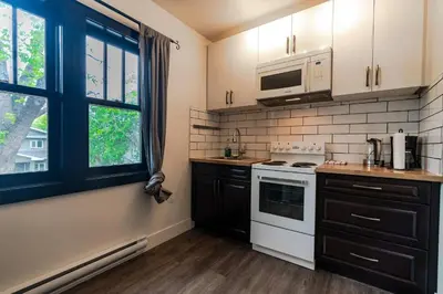 a kitchen with a white stove top oven next to a window at Historical Building 1br 1ba Walk To Rogers Place in Edmonton