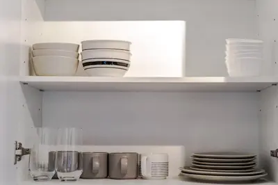 a kitchen shelf with plates and dishes on it at Historical Building 1br 1ba Walk To Rogers Place in Edmonton