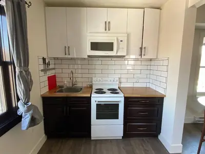 a kitchen with a white stove and a microwave at Historical Building 1br 1ba Walk To Rogers Place in Edmonton
