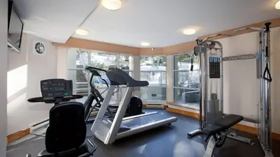 a room with a gym with a treadmill and a window at Woodrun Lodge 416 | Family Ski-In Ski-Out Condo, Hot Tub, Heated Pool, Parking & Laundry in Whistler