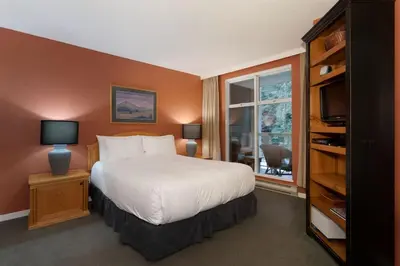 a bedroom with a large bed and a window at Woodrun Lodge 416 | Family Ski-In Ski-Out Condo, Hot Tub, Heated Pool, Parking & Laundry in Whistler