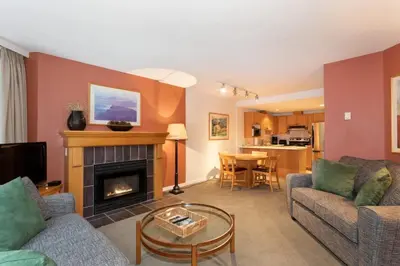 a living room with two couches and a fireplace at Woodrun Lodge 416 | Family Ski-In Ski-Out Condo, Hot Tub, Heated Pool, Parking & Laundry in Whistler