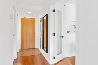 a hallway with white walls and a wooden door at Downtown Luxury 1BR Coal Harbour in Vancouver